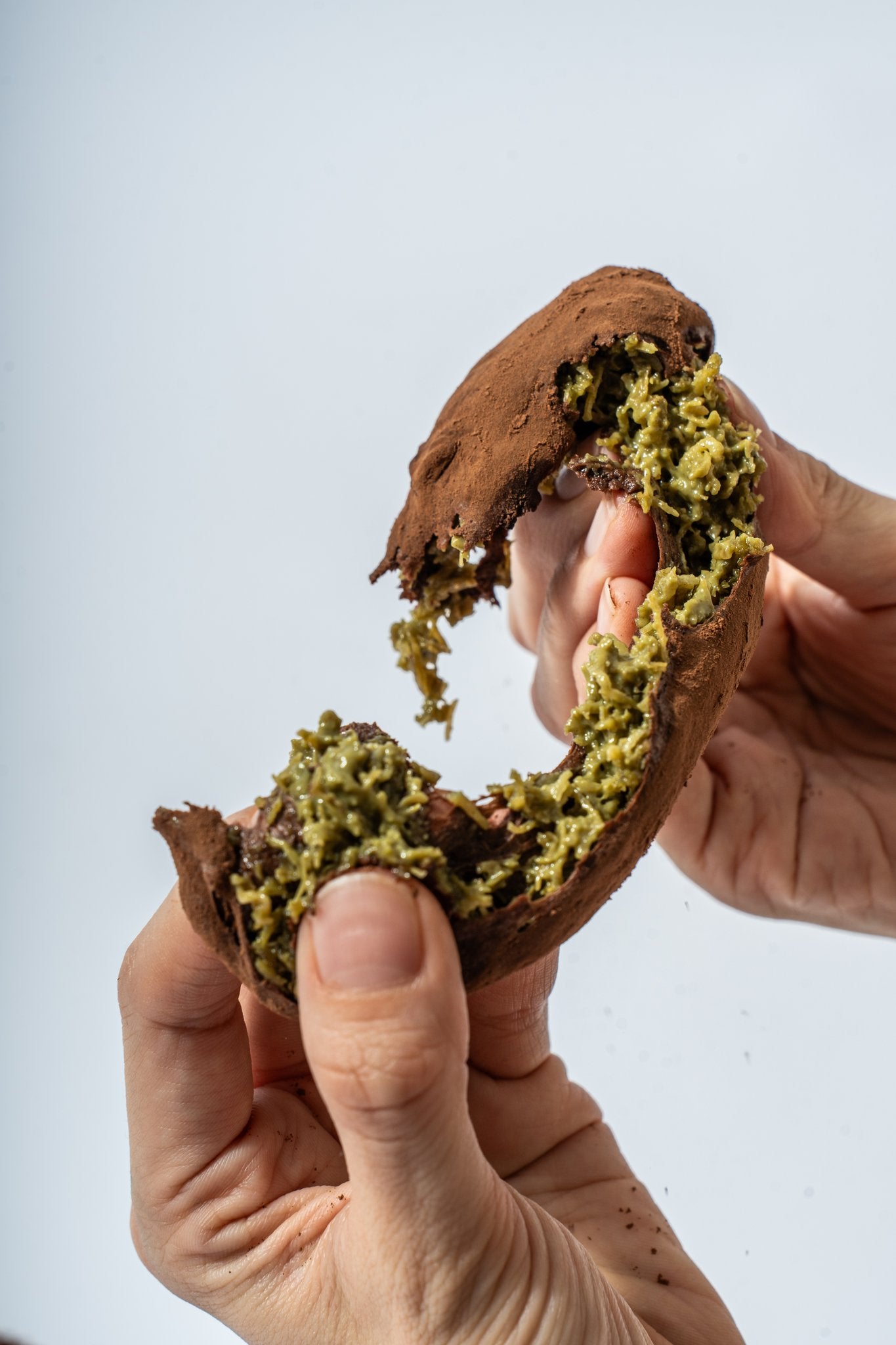 Hands pulling apart truffle revealing filling